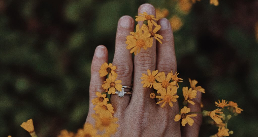 Emerald solitaire engagement ring on hand