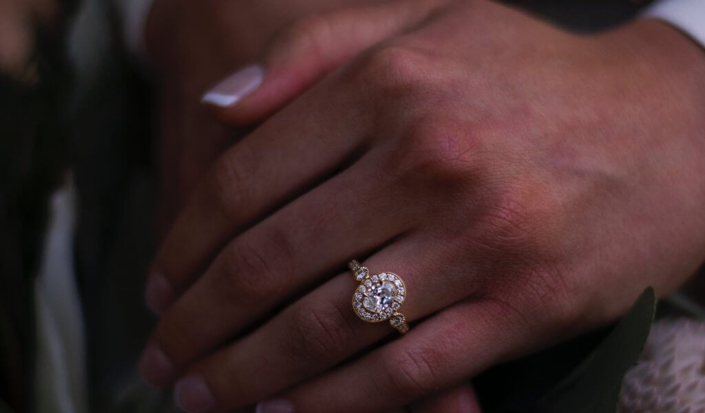 Oval halo engagement ring in yellow gold