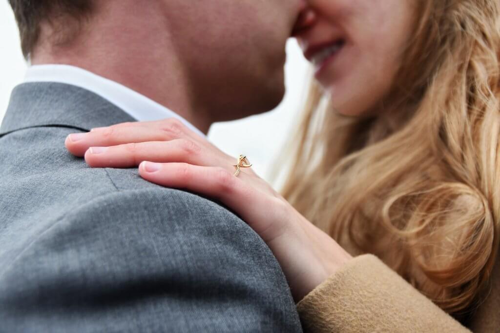 man-hugging-woman-with-a-solitaire-cut-diamond-engagement-ring-The-Diamond-Solitaire-Setting-2-1