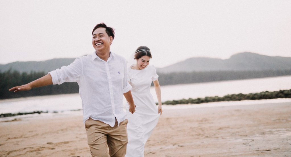 couple on wedding anniversary running beach