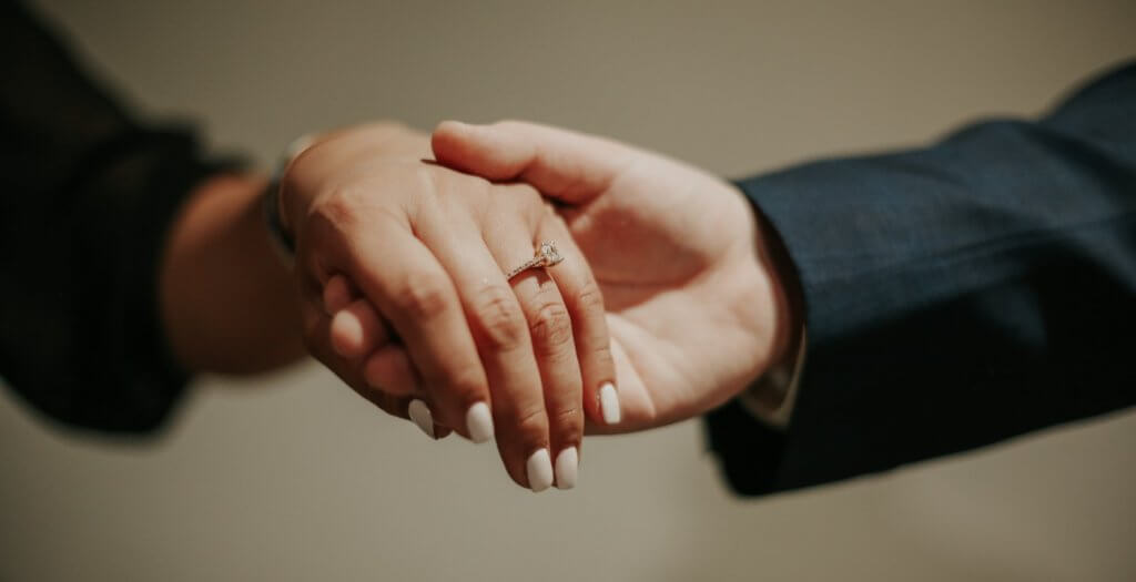 engagement ring on hands holding